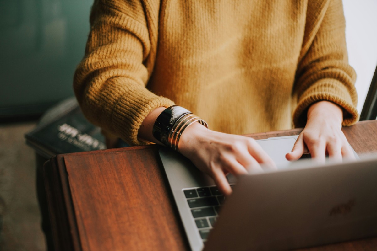 Personne qui écrit sur ordinateur sur un bureau